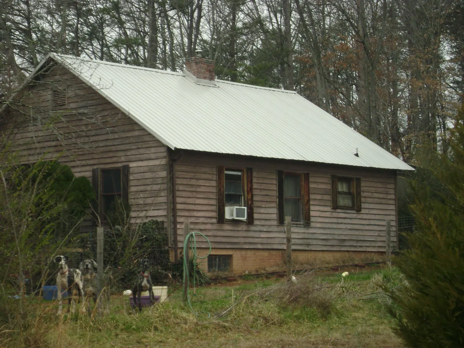 White metal roof on an old wood sided farmhouse, from a Metal Roof Installation job in Appling